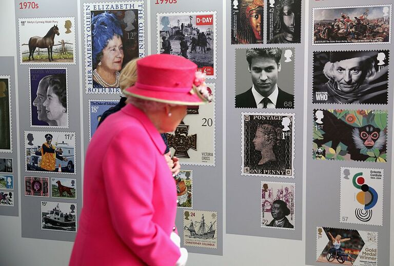 Britain's Queen Elizabeth II looks at a display of images of Royal Mail postage stamps