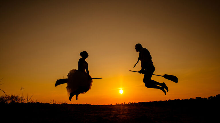 Couple flying on broomsticks
