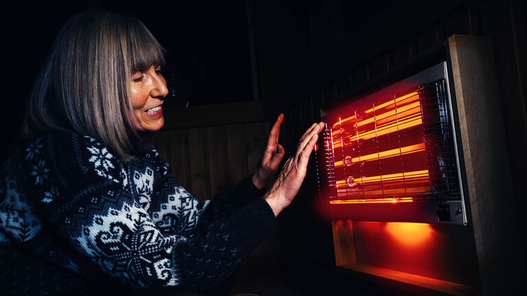 woman warming her hands with the satisfying infrared rays