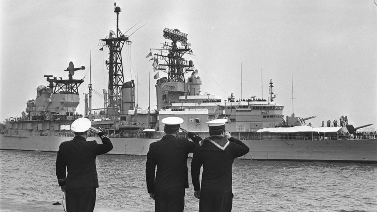Sailors saluting the USS Oklahoma City