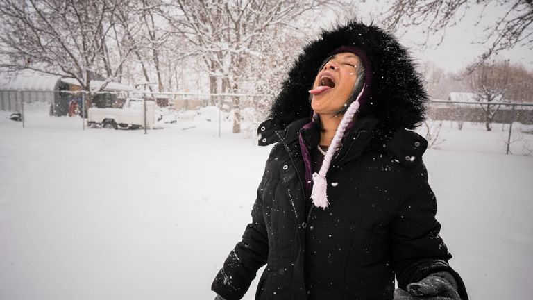 Woman catching snow on tongue