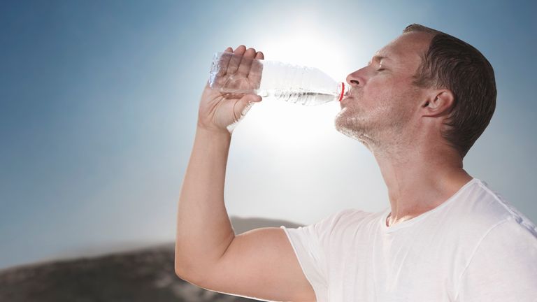 Hot sunny day drinking water from a bottle