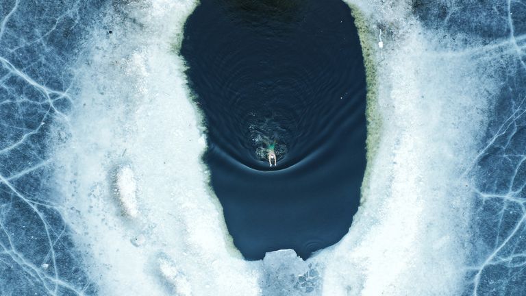 https://www.gettyimages.co.uk/detail/news-photo/aerial-view-of-a-winter-swimmer-swimming-in-a-pool-carved-news-photo/1301878324 swimming frozen lake
