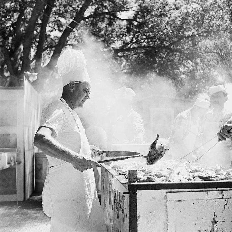 https://www.gettyimages.com/detail/news-photo/man-in-a-chefs-hat-lifting-a-bird-from-a-barbecue-as-smoke-news-photo/1441412332?adppopup=true