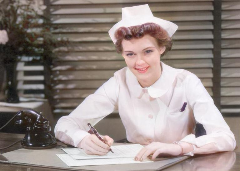 https://www.gettyimages.co.uk/detail/news-photo/nurse-smiles-while-writing-at-her-desk-in-a-doctors-office-news-photo/3245352