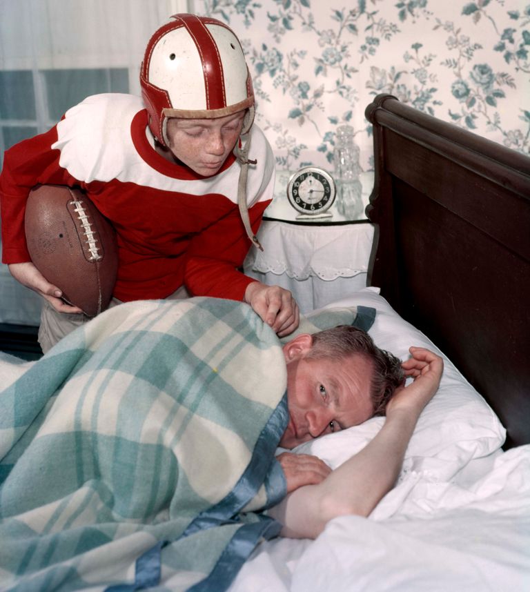 https://www.gettyimages.co.uk/detail/news-photo/1960s-boy-in-football-uniform-waking-father-asleep-in-news-photo/707706989